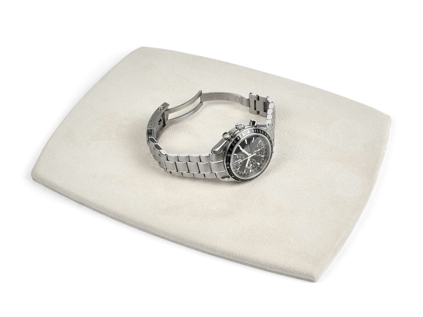 Silver watch on a biege watch pad with a white background